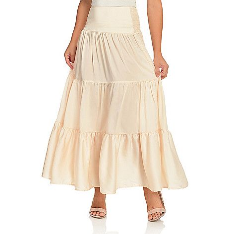 Let this long flowy skirt from Elan define your outfit! With a beautiful  flowy triple tier style and a smocked waist on the back  this maxi is not only a statement-maker  but a comfortable choice as well! The extra wide front waistband defines your figure and cascades down towards the three gauzy tiers below. Dress it up or keep it casual  the choice is yours with this skirt's neutral colors! Beach Tiered Ruffled Maxi Skirt, Bohemian Maxi Dress With Smocked Back And Tiered Skirt, Beach Tiered Maxi Skirt With Ruffled Details, Tiered Maxi Skirt For Vacation With Relaxed Fit, Relaxed Tiered Maxi Skirt For Vacation, Chic Tiered Voluminous Maxi Skirt, Chic Voluminous Tiered Maxi Skirt, Tiered Gathered Maxi Skirt For Summer, Tiered Ruffle Maxi Skirt For Vacation