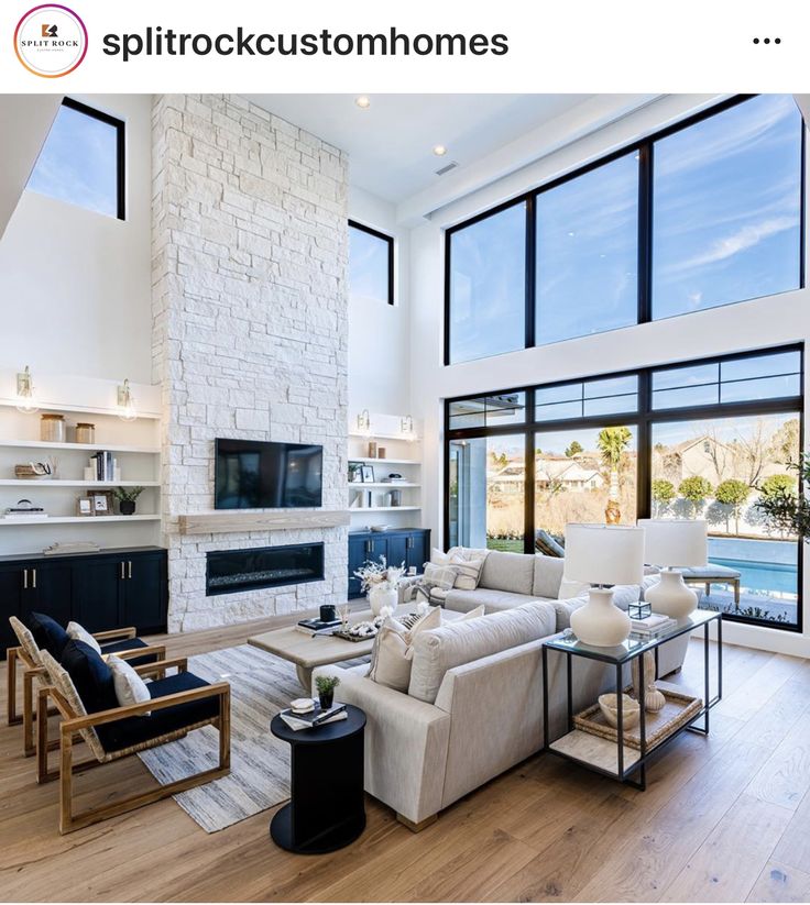 a living room filled with furniture and large windows