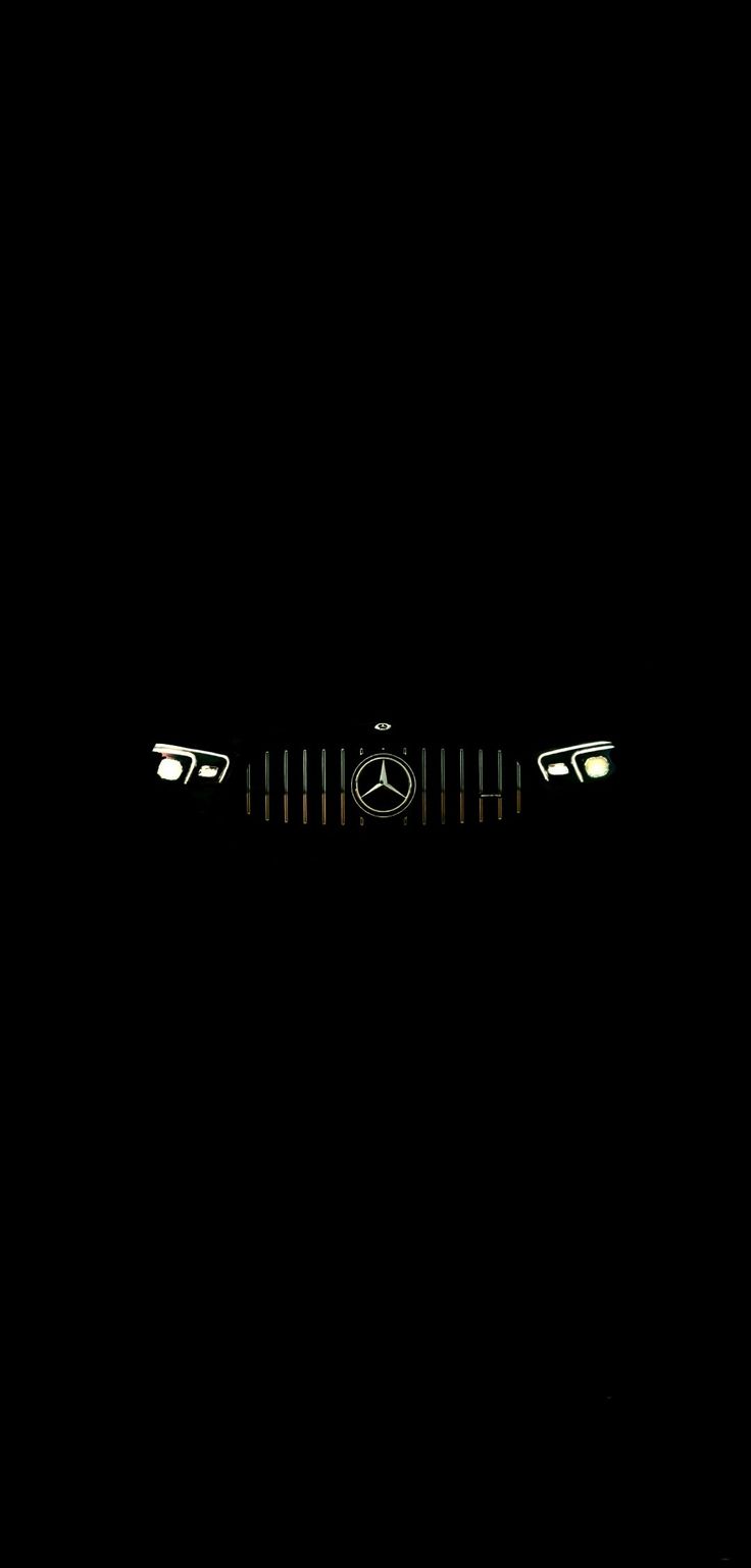 the mercedes logo is illuminated in the dark, with only one light visible on it