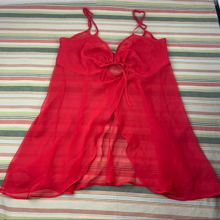 Red Sheer Babydoll Nightie. Adjuatable Straps. Cute Opening In Front. And Heart Tie Detailing At Front Center Midbreast. Excellent Preowned Condition But Never Used. No Flaws Noted. Just Minor Wrinkling From Being Stored In Drawer. See Measurements In Last 2 Pics. Pair This Negligee With Sheer Undies Or None. Whatever You Prefer! Red Summer Sleepwear, Red Summer Sleepwear For Bedtime, Red Spaghetti Strap Sleepwear For Summer, Red Party Sleepwear With Built-in Bra, Red Summer Camisole Sleepwear, Red Spaghetti Straps Sleepwear For Summer, Red Summer Sleepwear For Night, Red Coquette Style Sleepwear, Victoria's Secret Camisole For Vacation