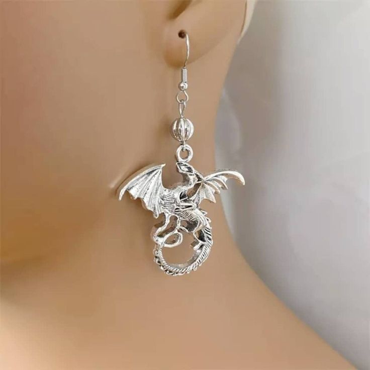 ♡ Silver Dragon Earrings ♡ ♡ These Mythical Animal Earrings are the perfect gift to delight yourself or those you love. Featuring silver dragon charms at center, these cute earrings highlight your outfit with a real depth of mythical beauty. These unusual earrings shine when kissed by the light, are very lightweight and super comfy to wear ♡ W H Y ∙ Y O U ' L L ∙ L O V E ∙ I T • Dainty and can be worn every day with any outfit • A special piece symbol you will adore • High quality materials and Alloy Drop Earrings With Ear Wire, Drop Earrings Cartilage Pierced As Gift, Pierced Drop Cartilage Earrings Gift, Alloy Drop Clip-on Earrings As Gift, Silver Drop Cartilage Earrings As Gift, Nickel-free Drop Cartilage Earrings As Gift, Metal Single Cartilage Earring As Gift, Single Alloy Earring As Gift, Hypoallergenic Dangle Cartilage Earrings As Gift