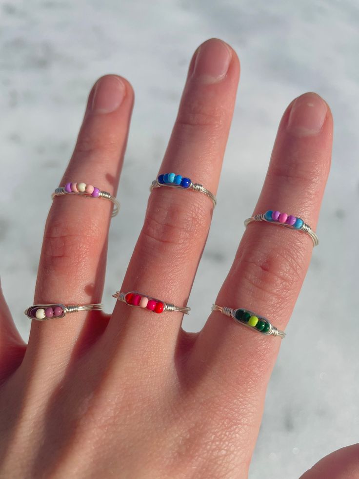 a person's hand with three different rings on their fingers and one is wearing a ring