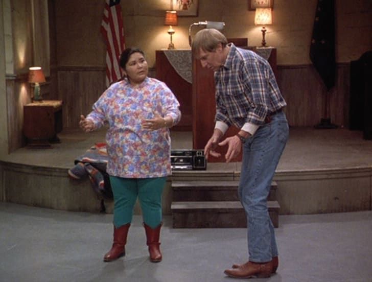 a man and woman standing in front of a stage