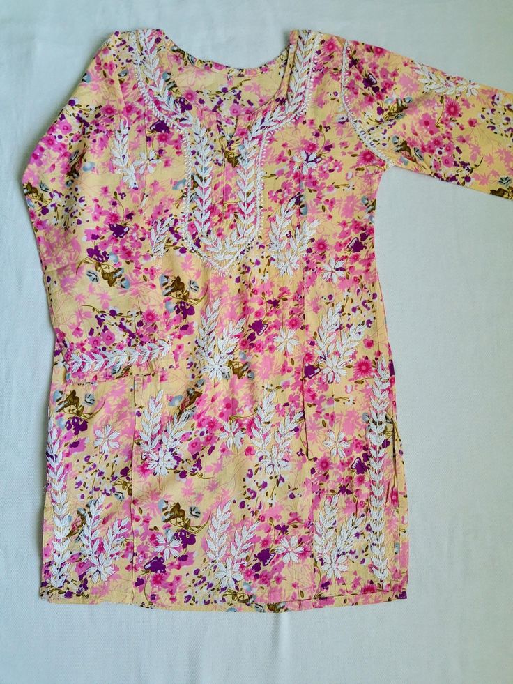 Elegant mul mul floral short chikankari kurta in short to be paired with palazzos,jeans . Length 30 inches Casual Multicolor Floral Print Lawn Suit, Yellow Cotton Lawn Suit For Summer, Summer Yellow Cotton Lawn Suit, Casual Pink Cotton Kurta, Cotton Chikankari Tunic Kurta, Cotton Chikankari Embroidery Tunic Kurta, Spring Cotton Salwar Kameez With Resham Embroidery, Spring Cotton Lawn Suit With Floral Embroidery, Spring Yellow Cotton Kurta