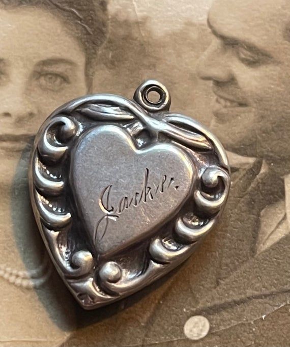 This is a sterling silver puffy heart from the 1940’s engraved with the name Jackie.Collect your friends and family names and monograms to create a really unique piece of jewelry that will become an heirloom passed down for generations. Remember to keep notes concerning the persons represented by the love token, puffy heart of charm. This is called the provenance of the piece and it increases the value of the item. More than a financial value, these types of heirlooms mean so much to those famil Classic Heart-shaped Collectible Jewelry, Classic Heart Jewelry For Collectibles, Classic Heart Shaped Collectible Jewelry, Collectible Heart-shaped Hallmarked Jewelry, Personalized Heart Jewelry Collectible, Vintage Sterling Silver Jewelry For Valentine's Day, Personalized Heart Jewelry For Collectors, Engraved Jewelry Collectible For Valentine's Day, Vintage Double Heart Personalized Jewelry