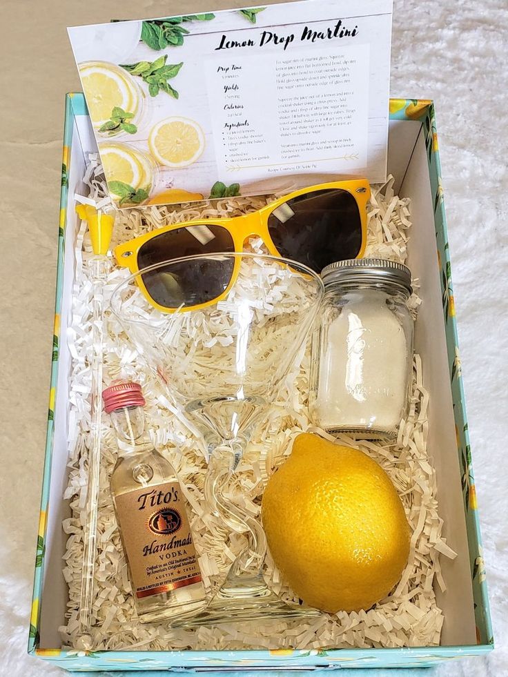 an open box containing glasses, lemons and other items to make a cocktail drink