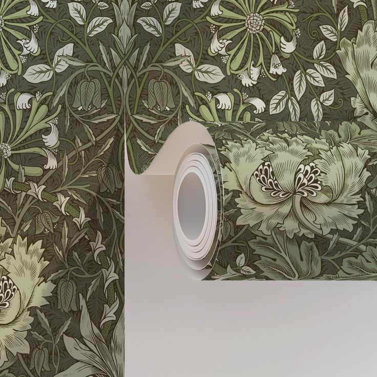 the wall paper is green and white with flowers on it, as well as a roll of tape