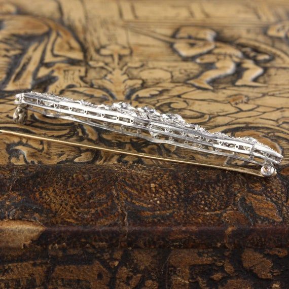 A stunning platinum and diamond bar brooch from the Edwardian era with beautiful and delicate milgraining.Item #JP-P0007Metal: PlatinumWeight: 12 GramsDiamond Weight: Approximately 3.50 ctsDiamond Color: HDiamond Clarity: VS2Measurements: 17 x 66 mmLayaway: For your convenience, we will be happy to provide layaway payment options. Please contact us to work out a layaway plan which best suits your needs. All layaway purchases are final sale.All domestic and international shipments are shipped wit Classic Diamond White Diamond Brooch, Elegant Silver Platinum Brooches, Classic Diamond Brilliant Cut Brooch, Classic Diamond Brooch With Brilliant Cut, Classic Platinum Brooch With Brilliant Cut, Classic Diamond Brooches With Brilliant Cut, Luxury Platinum Wedding Brooches, Classic Diamond White Brooch For Anniversary, Classic Platinum Brooches With Diamond Accents