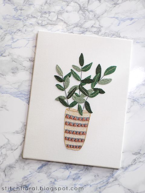 a card with a potted plant in it on a marble countertop next to a blue and white tile