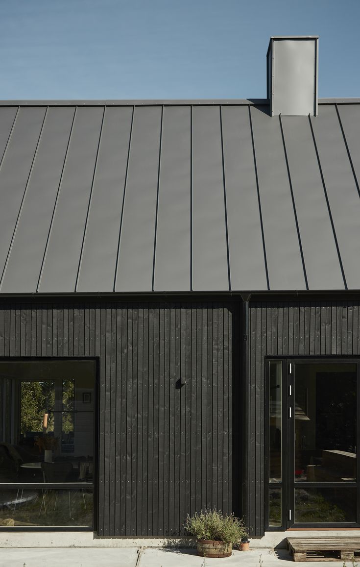 a black building with two windows and a bench