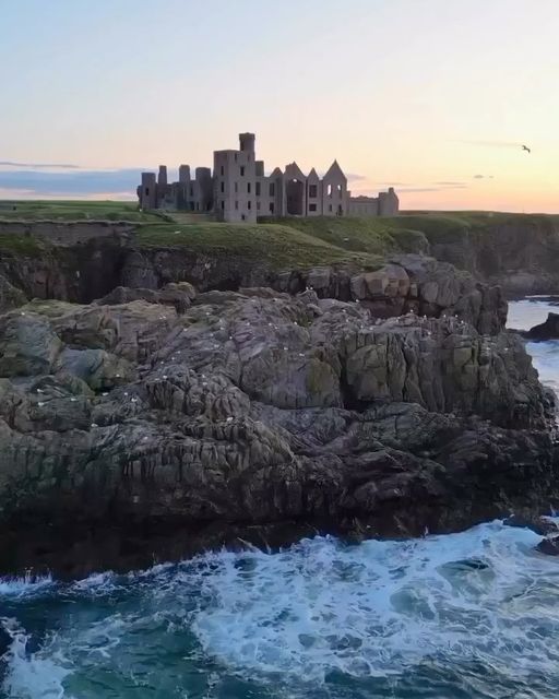 an old castle on top of a cliff next to the ocean