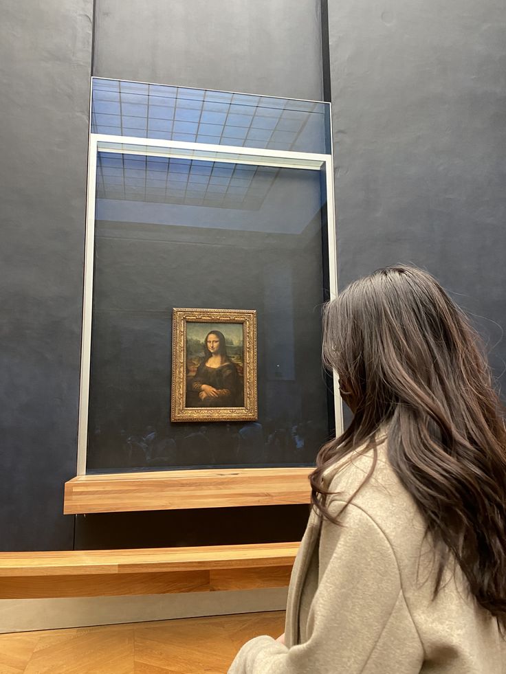 a woman looking at a painting in a museum