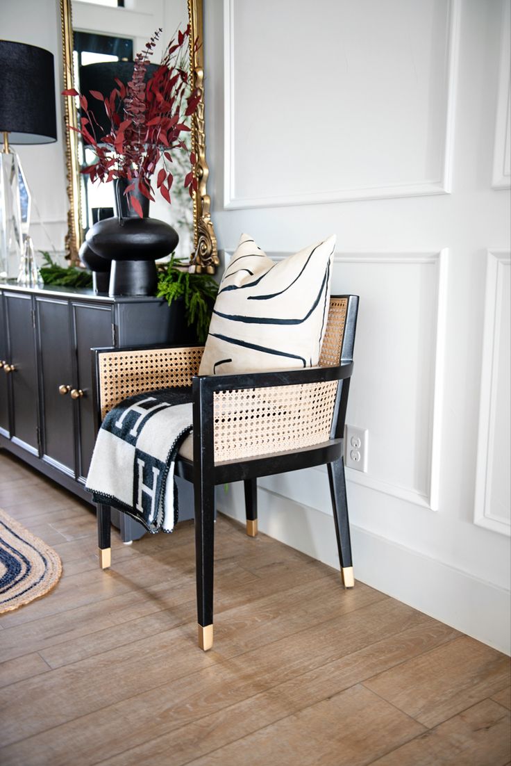 a chair sitting on top of a hard wood floor next to a dresser and mirror