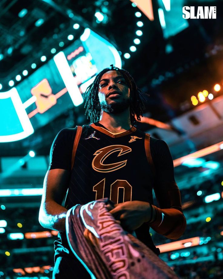 a man with dreadlocks holding a basketball