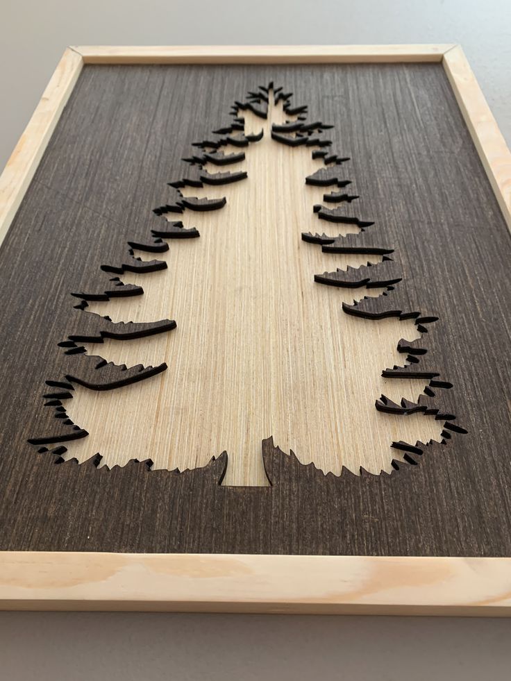 a wooden cutout of a christmas tree with many branches in the shape of trees