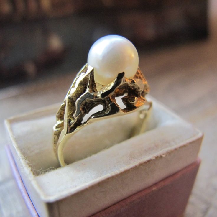 14k Yellow Gold Brutalist Pearl Statement Ring, Stamped 585, Fir/Pine Tree Makers' Mark, 14 Karat Yellow Gold Salt Water or Akoya Cultured Pearl Ring, Estate Gold Jewelry. Overall small size and look ring. True vintage 1970's approx age design, good condition, gently worn, if worn.  Circa 1970 585 Stamped Gold aka 14k  Makers' mark logo hallmark Tree  4.4 grams  On the ring mandrel this looks to be approx a size 4 or slightly bigger (it does not fit snug on mandrel)  7 MM pearl  10.5 MM or 7/16 IN Width tapering down to the below band width  2.35 MM Width Band  Good Estate Condition Gold Pearl Ring Stamped 14k For Gift, Exquisite Yellow Gold Collectible Rings, Gold Pearl Ring Stamped 14k As Gift, Formal 14k Stamped Round Pearl Ring, Antique Yellow Gold Jewelry For Anniversary, Heirloom Pearl Ring Stamped 14k As Gift, Oval Yellow Gold Pearl Ring With High Luster, Oval Pearl Ring In Yellow Gold With High Luster, 14k Gold Pearl Ring Stamped 14k