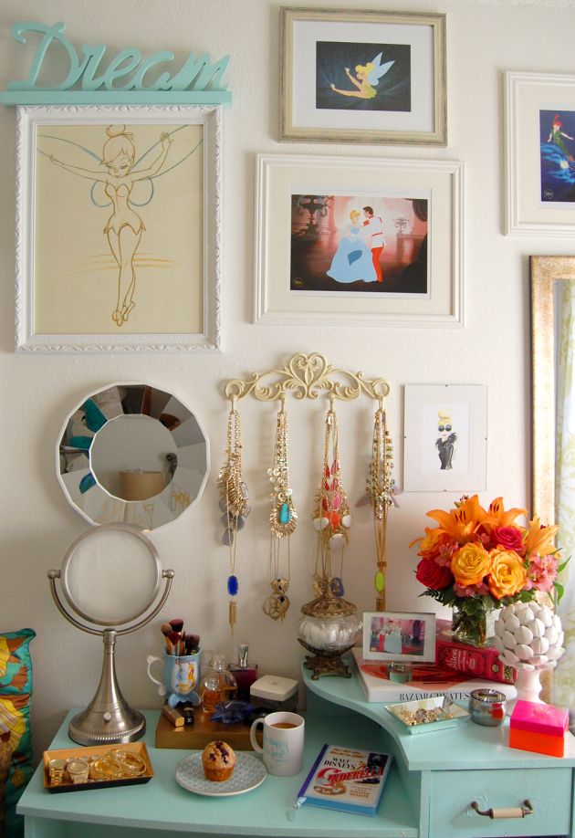 a blue desk topped with lots of pictures and jewelry