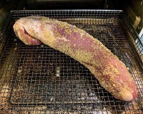 a large piece of meat sitting on top of a metal rack in an open oven