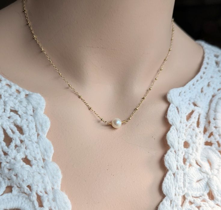 This romantic necklace combined intricately detailed 14kt gold filled satellite chain and a lustrous hand wired freshwater pearl.  The pearl is approximately 6 mm in size.  Please note that all metal material is gold filled.  Gold filled is high quality and lasting, not to be confused with gold plated brass. You may select your length when you add the item to your cart.  Note: most chokers are 14 or 15 inches.  Short necklaces are typically 16 inches. Standard necklaces are 17 or 18 inches.   Th Gold Pearl Necklace With Satellite Chain In Dainty Style, Pearl Necklace With Satellite Chain As Gift, Delicate Wire Wrapped Pearl Necklace As Gift, Pearl Satellite Chain Necklace As Gift, Delicate Wire Wrapped Pearl Necklace For Gift, Delicate Gold Wire Wrapped Pearl Necklace, Delicate Gold Wire-wrapped Pearl Necklace, Delicate 14k Gold-filled Necklace With Pearl Charm, Gold-tone Pearl Necklace With Adjustable Chain