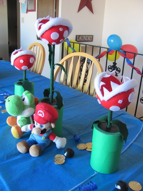 two stuffed animals sitting on top of a table next to each other in front of some decorations