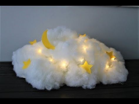 a white cloud with yellow stars on it and some lights in the shape of clouds