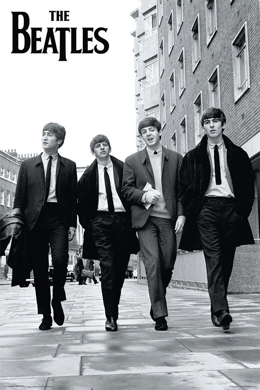 four men in suits walking down the street with one man wearing a suit and tie