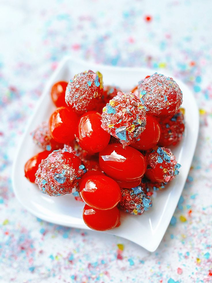 a white plate topped with candy covered in sprinkles on top of a table