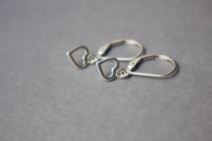 Adorable Sterling Silver Hearts, hanging from a Sterling Silver leverbacks, forming simple, lightweight and comfortable earrings for little girls. Just perfect for Birthday, Spring, Easter and every day wear. Is your girl asking for dangling earrings? These would be the perfect length! The earrings are slightly less than 1in (22mm) long and the heart charms are about 7mm long. More earrings for little girls can be found here: https://www.etsy.com/shop/EvaLineJewelry?ref=hdr_shop_menu&section Cute Silver Earrings For Anniversary, Sterling Silver Earrings With Ear Wire For Mother's Day, Adjustable Dangle Heart Earrings, Nickel Free, Silver Huggie Heart Earrings Gift, Sterling Silver Huggie Heart Earrings For Pierced Ears, Cute Silver Drop Earrings, Adjustable Dangle Heart Earrings, Adjustable Heart Shaped Drop Earrings, Nickel Free Heart Earrings