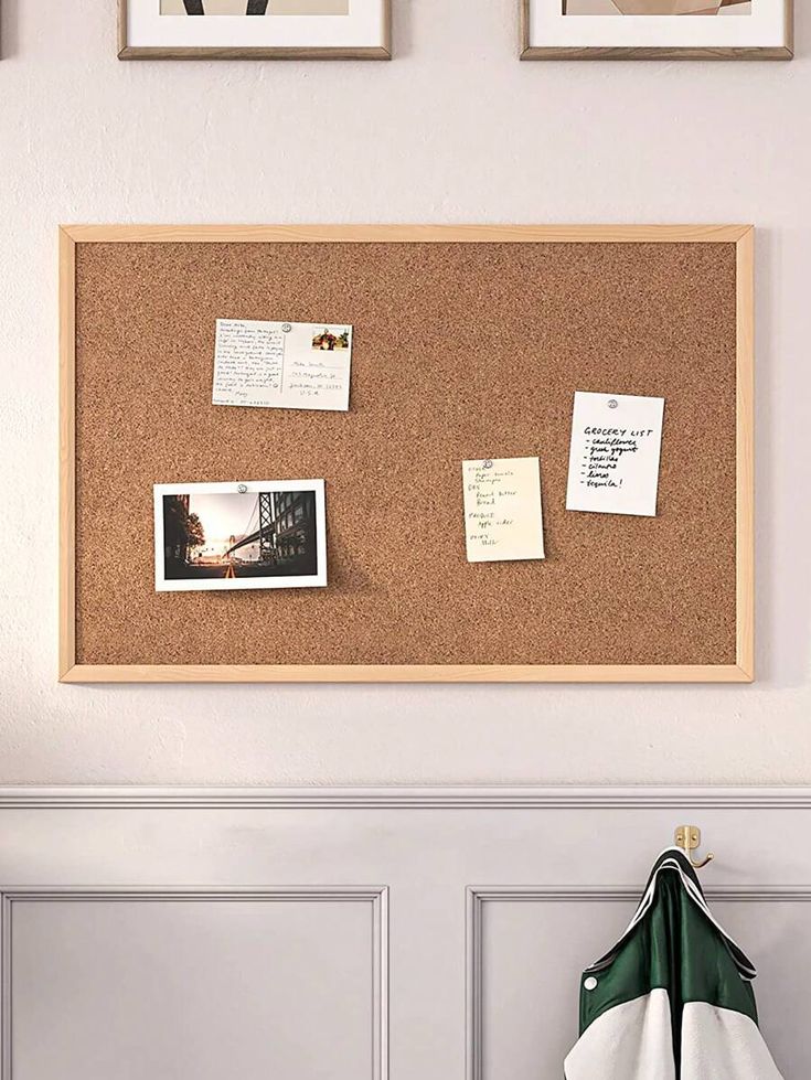 a cork board mounted to the side of a wall with pictures and memos on it