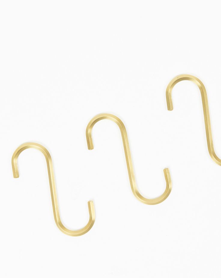 two gold hooks on a white background