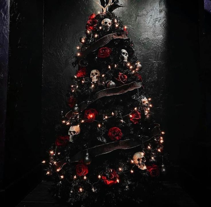 a decorated christmas tree with skulls and roses on it in a dark room at night