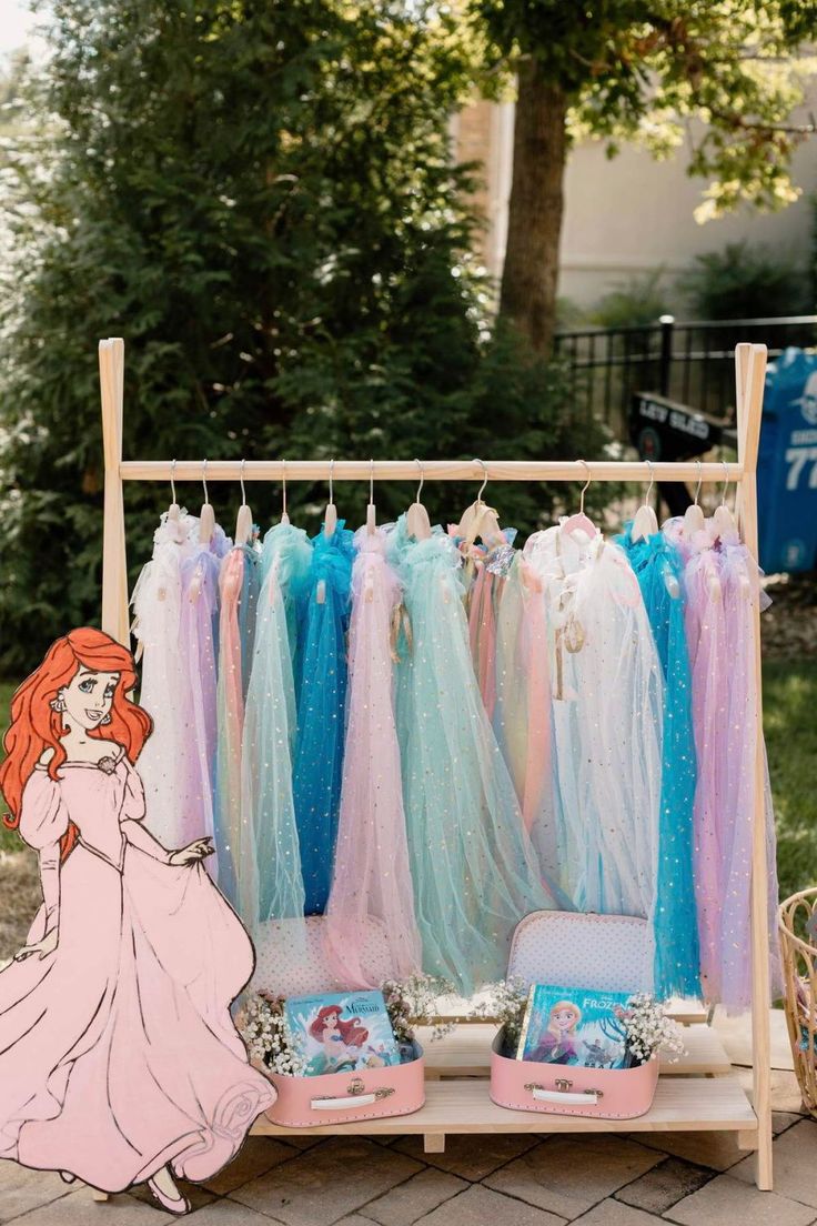 a display with princess dresses on it and other items in front of the rack for sale