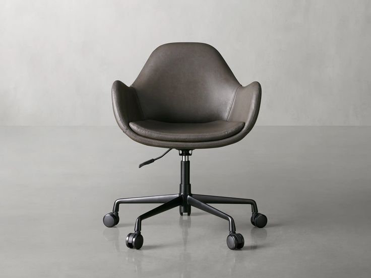 an office chair with casteors and wheels on a gray floor, in front of a white wall