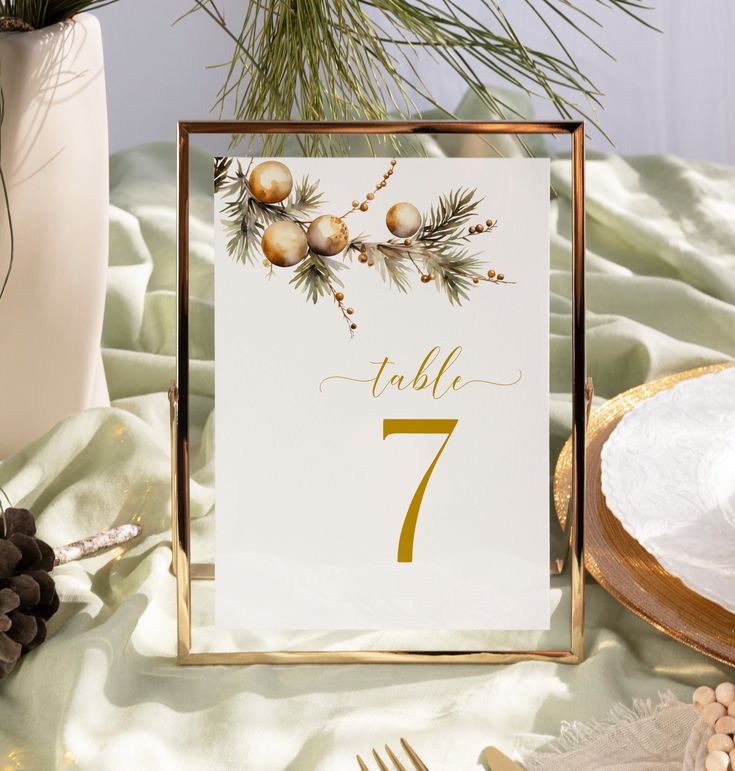 a table number with pine cones and berries on it