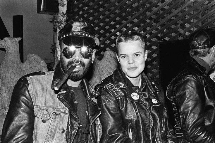 black and white photograph of two men in leather jackets, one with his face painted