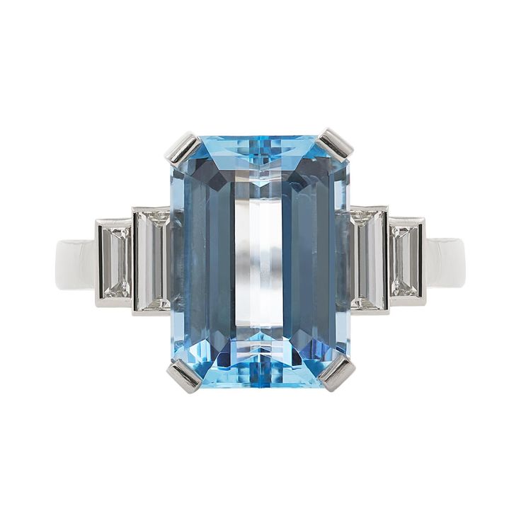 E Wolfe & Co Handmade Platinum Aquamarine and Diamond baguette Ring. The emerald-cut aquamarine centre stone weighs 4.33 carats and has two pairs of baguette diamonds set to either side of the platinum ring band. The baguette diamonds have a total weight of .60 carats and are of G colour and VS clarity. The ring was handmade at our London Workshop during 2021 and it weighs 6.81 grams. Currently the ring is a British finger size J 1/2 but it can be increased or reduced in size as is required. Luxury Topaz Baguette Cut Ring, Luxury Baguette-cut Topaz Ring With Center Stone, Luxury Baguette Cut Topaz Ring With Center Stone, Luxury Baguette Cut Topaz Ring, Modern Blue Rings With Baguette Diamonds, Luxury Blue Topaz Baguette Cut Rings, Luxury Aquamarine Baguette Cut Jewelry, Luxury Aquamarine Jewelry In Baguette Cut, Modern Octagon Topaz Gemstone Ring