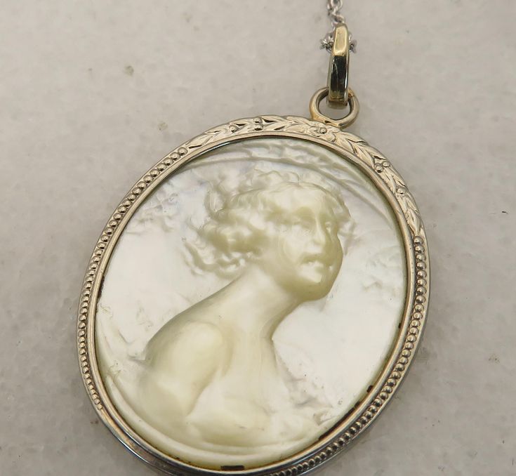 Estate art deco rare one of a kind mother of pearl carved woman set in 14k white gold. chain is 14k white gold also. 18 inchs. great shape. inscribed on back. will pack well. 3.3 grams. Art Deco White Gold Oval Necklace, Elegant Carved Round Pendant Necklace, Elegant Carved Pendant Necklace, Formal White Gold Carved Jewelry, Vintage Carved White Gold Jewelry, Hallmarked White Gold Necklace For Memorial, Carved White Gold Pendant Jewelry, White Engraved Necklace For Formal Occasions, Formal White Engraved Necklace