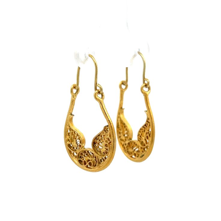 These vintage Mid-Century hoop drop earrings bring a timeless beauty to any outfit. Crafted from polished 18 karat yellow gold, these earrings feature an intricate filigree design that adds a unique detailing. The earrings have an elegant hoop design that hangs beautifully, adding a hint of movement to your look. Perfect for both day and night wear, they are a wonderful addition to any jewelry collection. Celebrate the charm of a bygone era with these exquisite earrings, combining historical elegance with modern style. Intricate Brass Hoop Earrings, Vintage 22k Gold Earrings, Vintage Yellow Gold Earrings With Intricate Design, Vintage 22k Yellow Gold Earrings, Luxury Yellow Gold Plug Earrings, Vintage 14k Gold Earrings With Intricate Design, Yellow Gold Filigree Plug Earrings, Yellow Gold Oval Filigree Earrings, Elegant Oval Earrings With Intricate Design