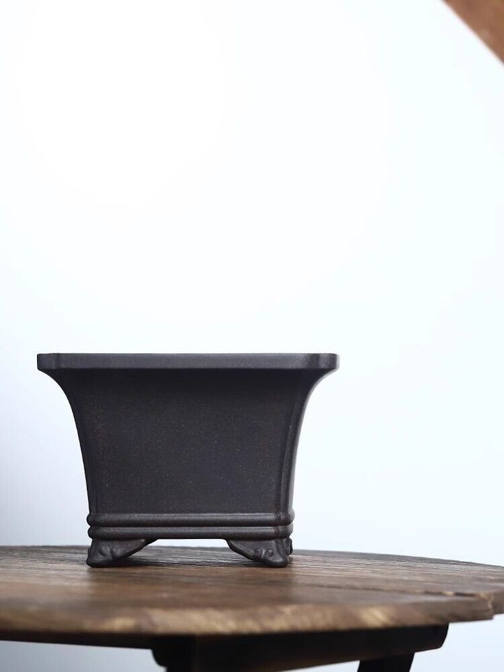 a black pot sitting on top of a wooden table