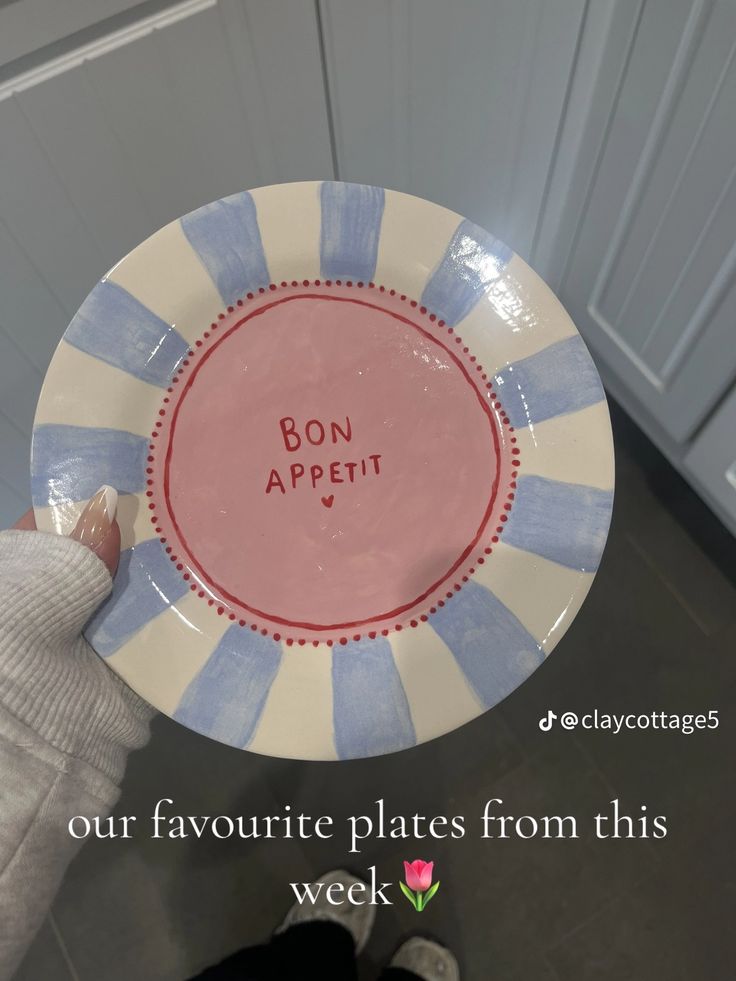 a person holding up a plate with the words bon appetit written on it