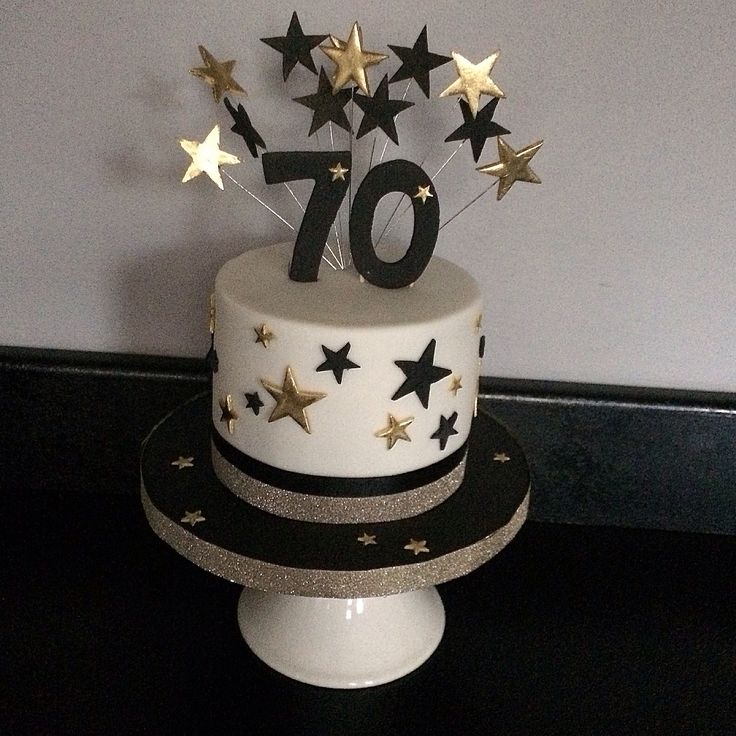 a white and black cake with gold stars on top