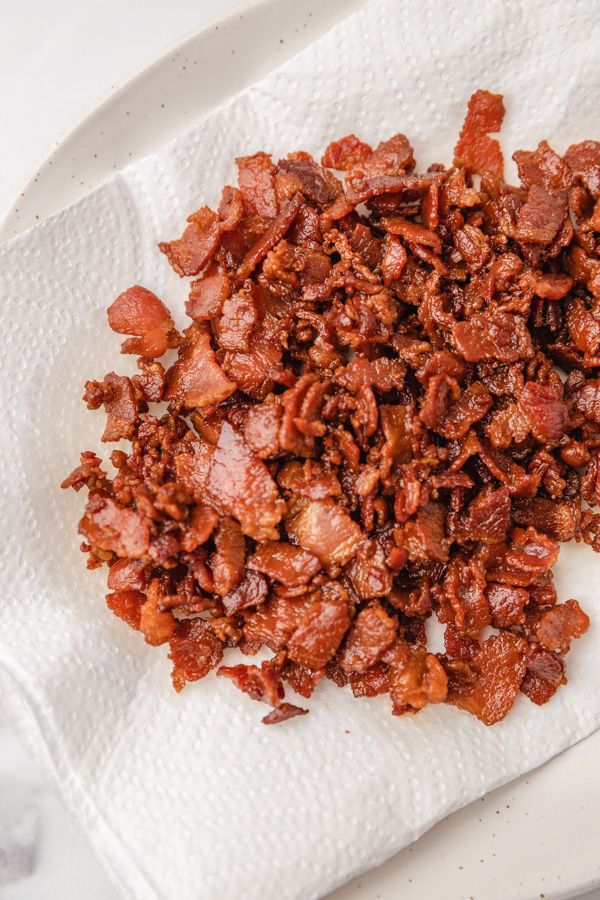 a pile of bacon sitting on top of a white plate