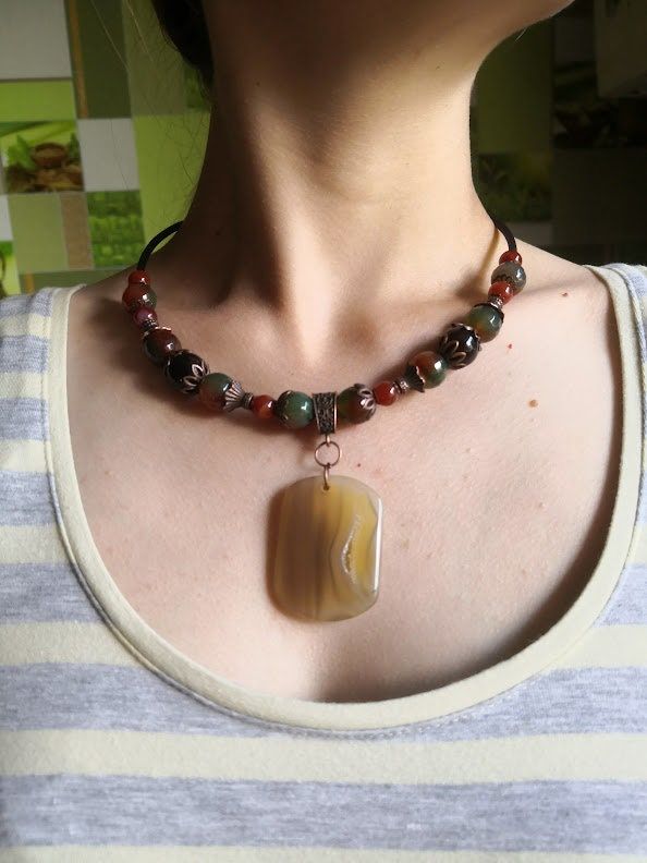 This necklace is made of round carnelian beads is such a dold and stunning necklace on, with edgy artisan appeal. In the center of the necklace is a large flat pendant of agate. This necklace can be worn by stylish men and women.       Such a dold statement maker, unique and very artisan. So stunning on, ful of vibrant light and color, reflection, this is day every day necklace yoif looking for - with jeans and a blouse, or dressed up, it goes with everything, enjoy.       According to astrologe Unique Adjustable Amber Beaded Necklace, Bohemian Agate Beaded Necklace With Polished Beads, Bohemian Agate Polished Beads Necklace, Adjustable Bohemian Agate Beaded Necklaces, Agate Pendant Jewelry For Festivals, Bohemian Agate Pendant Necklace, Festival Agate Pendant Jewelry, Unique Handmade Brown Choker, Hippie Style Red Jewelry For Gift