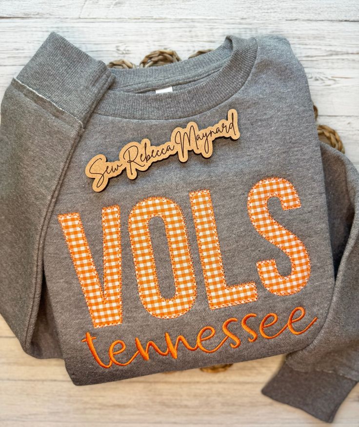 This beautiful Tennessee Volunteers embroidery appliqué design is the perfect addition to anyone's fall and winter wardrobe and perfect for those cool weather SEC football games! This LAT apparel tunic style crewneck sweatshirt features a drop-shoulder, ribbed cuffs and bottom band, raw edge seam at sleeve cuffs and bottom band, and a longer length silhouette with drop tail curved bottom hem. Choose between heathered granite or heathered natural sweatshirt - listing photo is heathered granite color *WASH AND CARE: - Wash in cold water on gentle cycle - Hang to dry or Tumble dry low - Use a warm iron if needed for any wrinkles *RETURNS & EXCHANGES: Due to the personalization of our items we cannot accept returns. If we make a mistake we will gladly issue a refund or ship out a replacement. Tennessee Embroidery Designs, Tn Vols Gameday Outfit Women, Embroidered Tops For College In Fall, Embroidered Graphic Tops For College In Fall, Embroidered Fall College Top, Fall College Top With Embroidered Graphics, Fall Tops With School Spirit Letter Embroidery, Embroidered Logo Tops For Game Day In Fall, Embroidered School Spirit Tops For Fall