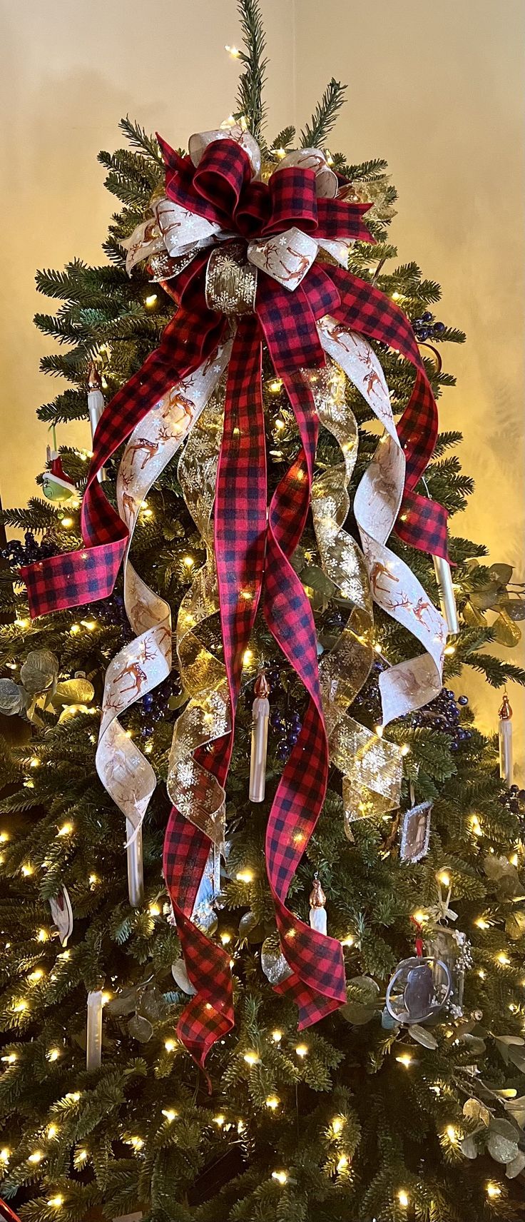 a christmas tree decorated with ribbons and lights