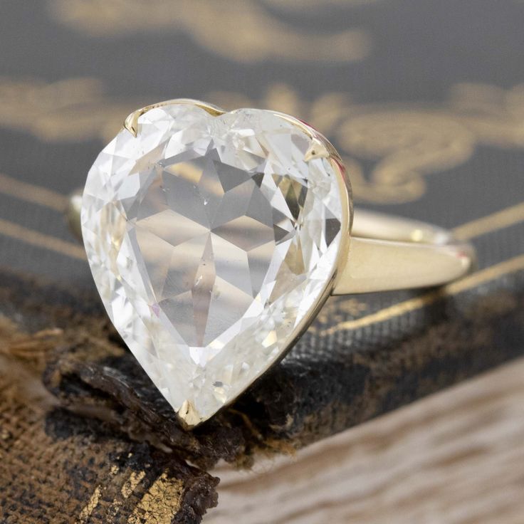 a heart shaped diamond sitting on top of a book