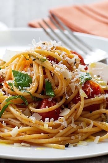 a plate of spaghetti with tomato sauce and parmesan cheese on top, ready to be eaten