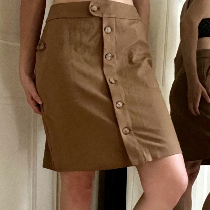 Awesome Skirt For The Office, Class, Vacation, Or A Casual Hike It Has Pockets! Kind Of A Dark Camel /Cafe Au Lait Sort Of Color The Pictures Where Model Is Wearing Are Truest To Color. Faux Tortoiseshell Buttons Complement The Tan Color Size Xs Shown On 6/8 5’8” 34”-29”-37”Runs A Bit Big Never Worn, New With Tags Including The Spare Bag O Buttons Viscose Rayon / Nylon / Spandex Blend Pencil Skirt A Line Professional Job Interview Academia Bougie Old Money Look Aesthetic Sporty Coastal Chic Vani Brown Mini Skirt With Button Closure For Work, Brown Knee-length Skirt With Button Closure, Workwear Mini Skirt With Side Buttons, Casual Skort With Button Closure For Work, Fitted Cargo Skirt With Button Closure, Casual Fitted Skirt With Side Buttons, Mini Skirt With Side Buttons For Work, Fitted Casual Skirt With Side Buttons, Relaxed Knee-length Skirt With Button Closure