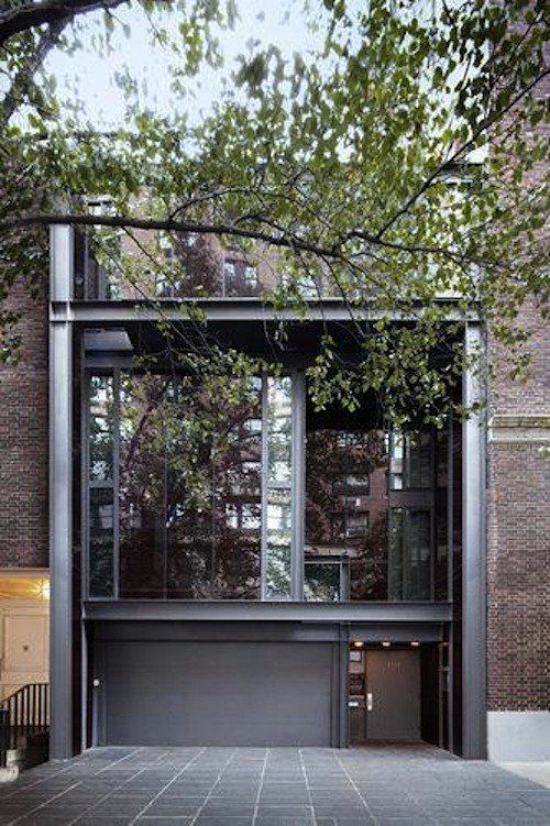 the entrance to an apartment building with large windows