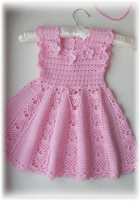 a pink crocheted dress hanging on a clothesline